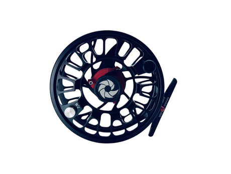 Närbild av svart GTS Reel flugfiskerulle med röd detalj, öppen design, kolfiberbroms och lätt spole på vit bakgrund.